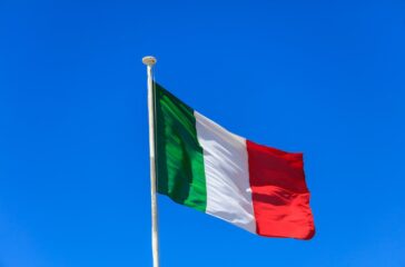 italy-flag-italian-flag-on-a-pole-waving-on-blue-sky-background-1024x682