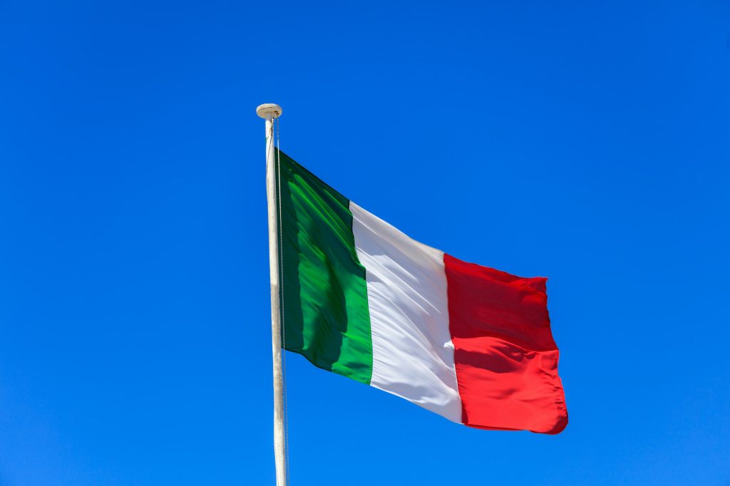 italy-flag-italian-flag-on-a-pole-waving-on-blue-sky-background-1024x682